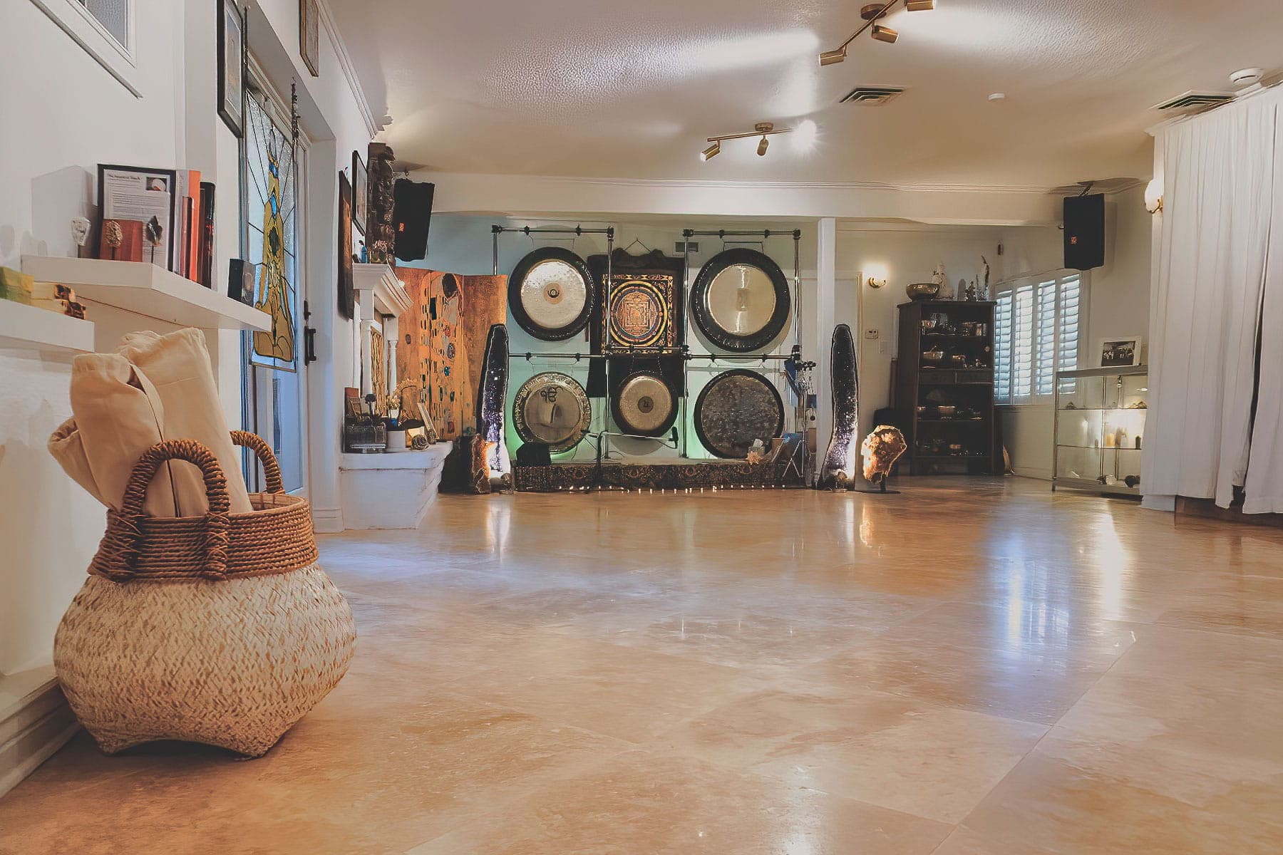 Spacious yoga and meditation hall at The MataJi Sanctuary with large gongs for sound healing and breathwork sessions.