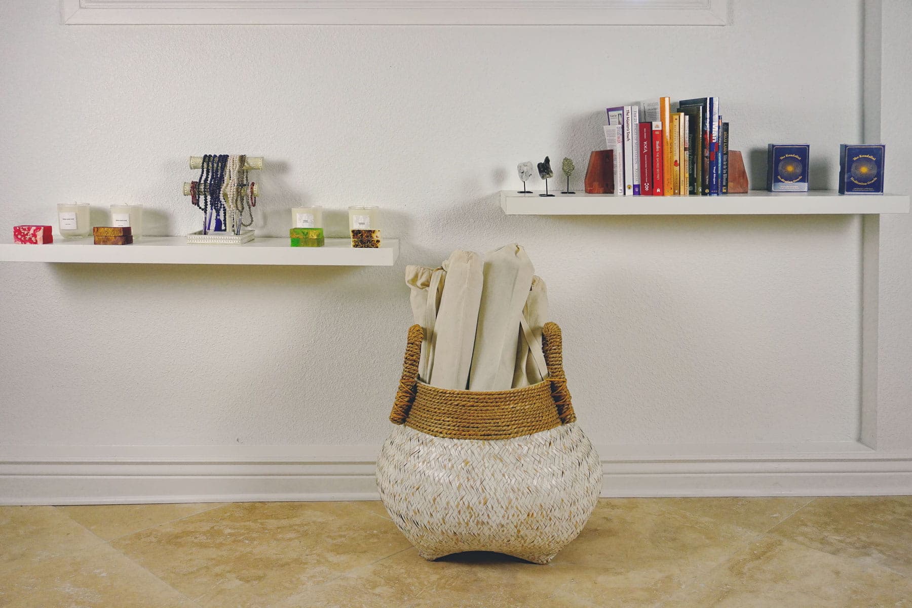 Yoga blankets in a woven basket at The MataJi Sanctuary, with candles, crystals, and books creating a peaceful meditation space.